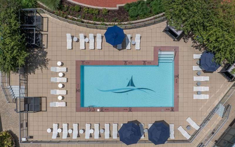 an aerial view of a pool with lounge chairs