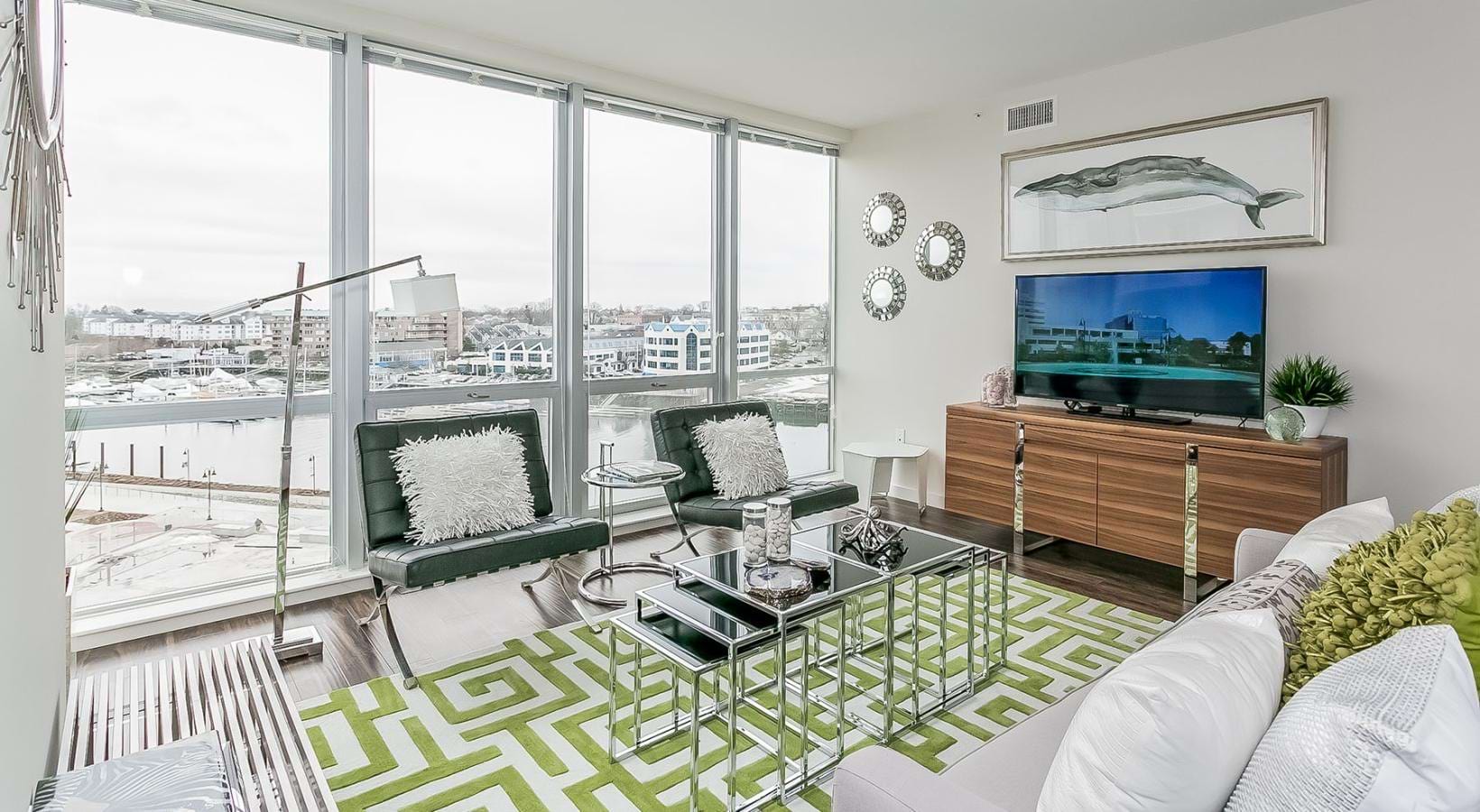 a living room with a tv, couch and chairs