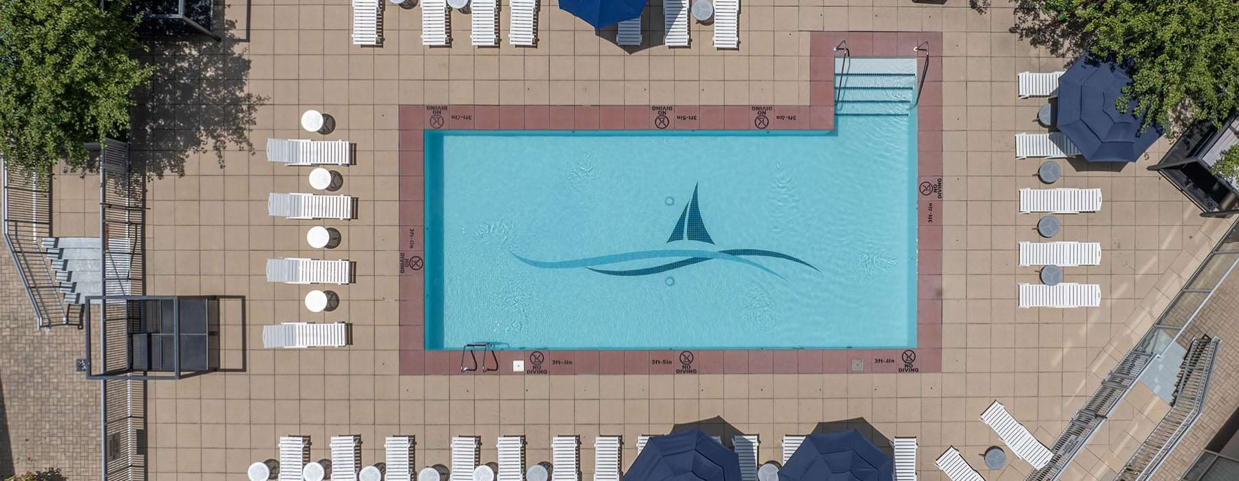 an aerial view of a pool with lounge chairs